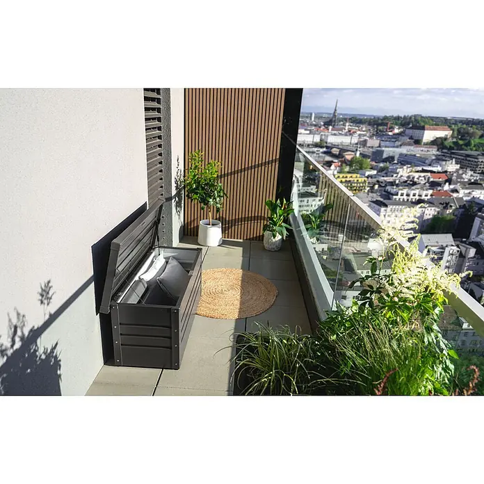 Biohort Kissenbox - 101 x 46 x 46,5 cm, Metall, Anthrazit - Dunkelgraue Aufbewahrungsbank mit offenem Deckel und grauen Kissen auf einem Balkon.