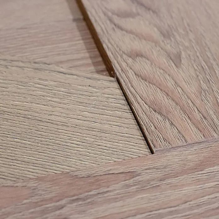 Inova Schiebetür-Komplettset Holzschiebetür Komplettset Eiche Doppelflügelig - 2.050 x 2.150 mm - Nahaufnahme von hellbraunem Holzboden mit Maserung und ineinandergreifenden Dielen in geometrischem Muster.