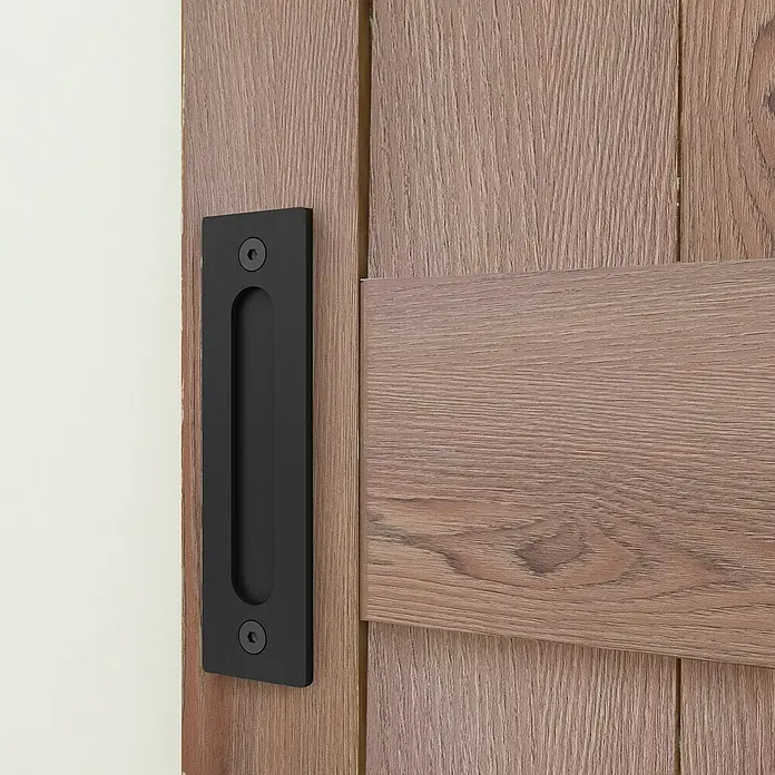 Inova Schiebetür-Komplettset Holz Scheunentor Eiche inkl. Softclose - 775 x 2.065 mm - Schwarzer, flacher Schiebetürgriff an einer hellen Holztür.