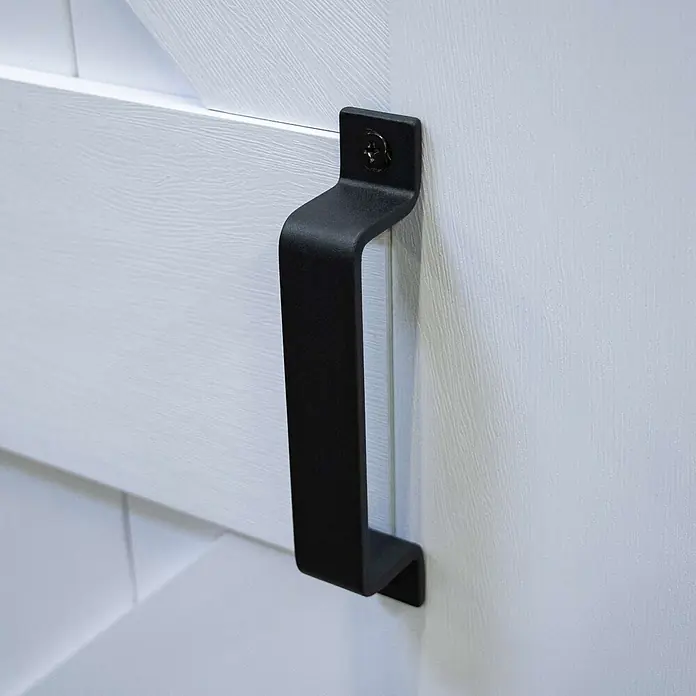 Inova Schiebetür-Komplettset Holz Scheunentor Weiß inkl. Softclose - 900 x 2.150 mm - Mattschwarzer Schiebetürgriff mit Kreuzschlitzschraube, an weißer strukturierter Tür montiert.