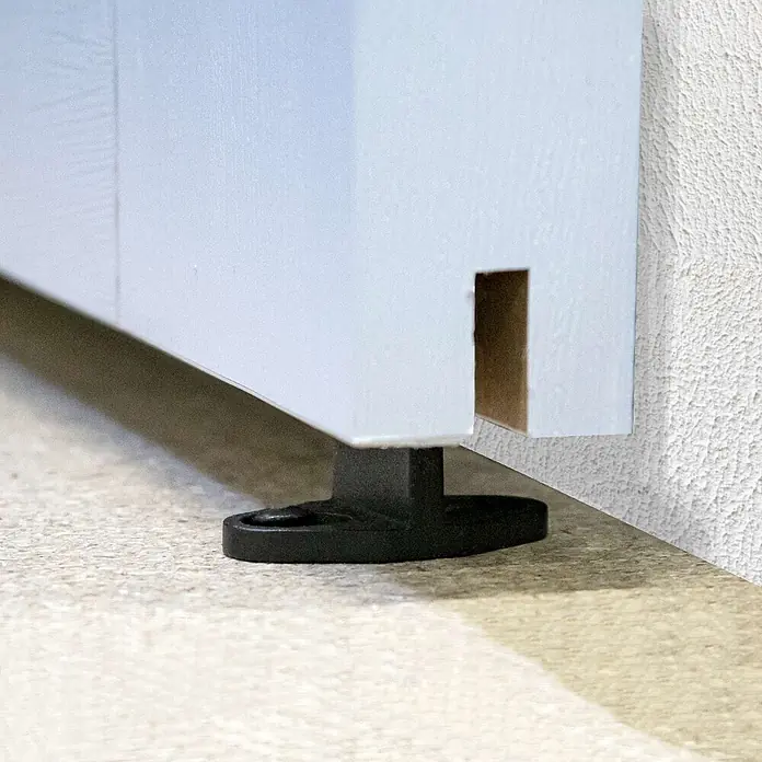 Inova Schiebetür-Komplettset Holz Scheunentor Weiß inkl. Softclose - 900 x 2.150 mm - Weißer Sockel mit schwarzem verstellbarem Kunststofffuß. Der Sockel hat einen rechteckigen Ausschnitt rechts.