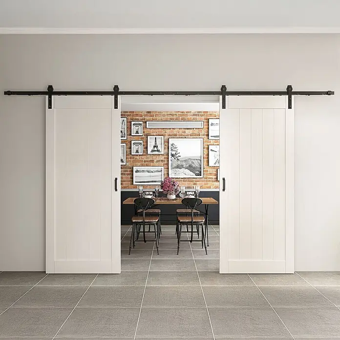 Inova Schiebetür-Komplettset Holzschiebetür Komplettset Weiß Doppelflügelig - 1.800 x 2.150 mm - Zwei weiße Schiebetüren mit schwarzer Laufschiene, teilweise geöffnet zu einem Esszimmer.