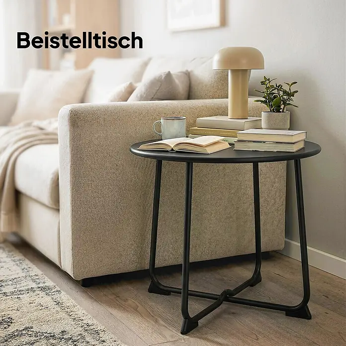 Outsunny Balkontisch rund - Ø x H: 50 x 45,5 cm, Metall, Schwarz - Schwarzer Beistelltisch aus Metall neben einem beigen Sofa, mit Büchern, Lampe und Pflanze.
