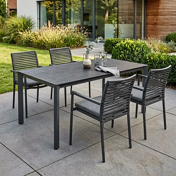 Acamp Gartenmöbel-Set New Jersey - 5 -tlg., Aluminium, Anthrazit - Dunkelgraue Outdoor-Essgruppe mit rechteckigem Tisch und vier Stühlen mit geflochtenen Rückenlehnen und grauen Kissen auf einer Terrasse.