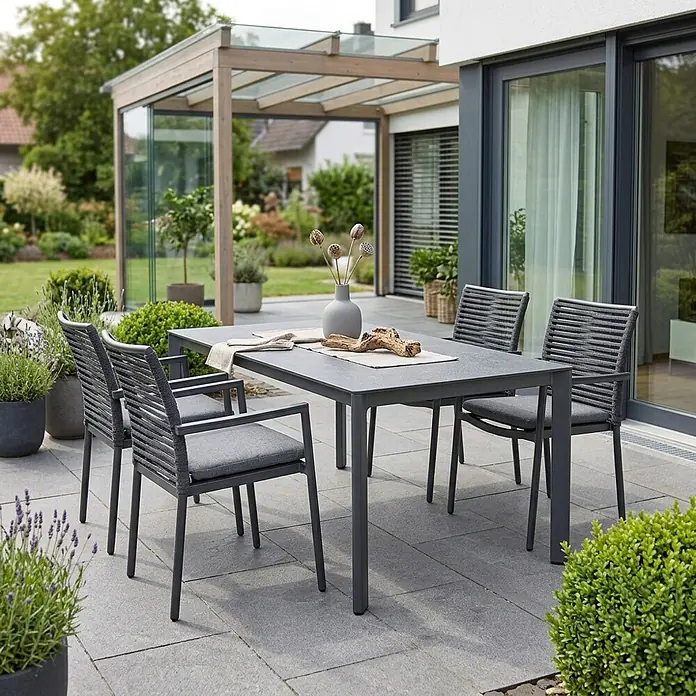 Acamp Gartenmöbel-Set New Jersey - 5 -tlg., Aluminium, Anthrazit - Moderne, dunkelgraue Outdoor-Essgruppe: rechteckiger Tisch und vier Stühle mit geflochtenen Lehnen und grauen Kissen auf einer Terrasse.