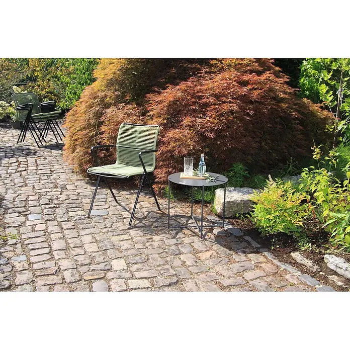 Acamp Stapelsessel Alpha Rope - Grün, 57 x 55 x 83 cm, 4 -tlg. - Hellgrüner Gartenstuhl mit schwarzem Metallgestell auf Kopfsteinpflaster neben einem kleinen schwarzen Beistelltisch.