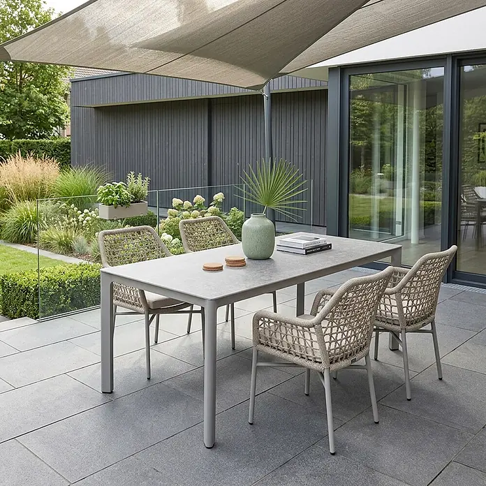 Acamp Gartenmöbel-Set Rom/Rom - 5 -tlg., Aluminium, TexRope, Grau,Beige - Modernes Outdoor-Essgruppe mit grauem Tisch und vier geflochtenen beigefarbenen Stühlen mit hellen Polstern auf einer Terrasse unter einem Sonnensegel.