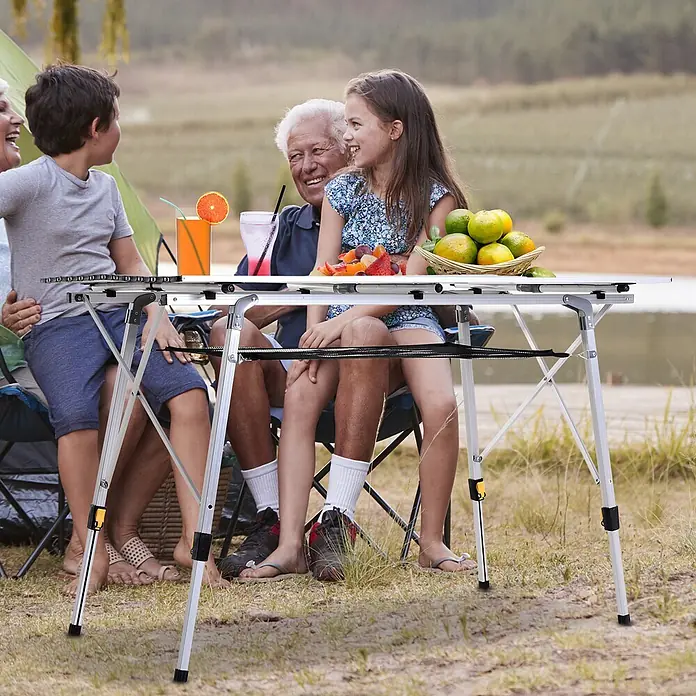 Outsunny Campingtisch - L x B x H: 120 x 69 x 78 cm, Aluminium, Netzstoff, Silber, Klappbar - Silberner Klapp-Campingtisch, von einer Familie im Freien genutzt, mit stabilem Design für Mahlzeiten und Aktivitäten.