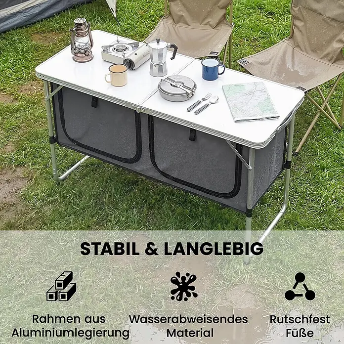 Outsunny Campingtisch - L x B x H: 120 x 47 x 70 cm, Aluminiumlegierung, Oxford, MDF, Silber, Klappbar - Klappbarer Campingtisch mit Aluminiumrahmen und zwei grauen Staufächern, im Freien mit Campingausrüstung aufgestellt.