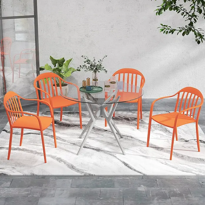 Outsunny Gartenstuhl-Set - 4 Stk., Kunststoff, Stapelbar, Rot, B x T x H: 54 x 57 x 78 cm - Gartengarnitur mit rundem Glastisch auf grauem Sternfuß und vier orangefarbenen Stühlen mit Lattenrücken, auf einem Terrassenteppich.