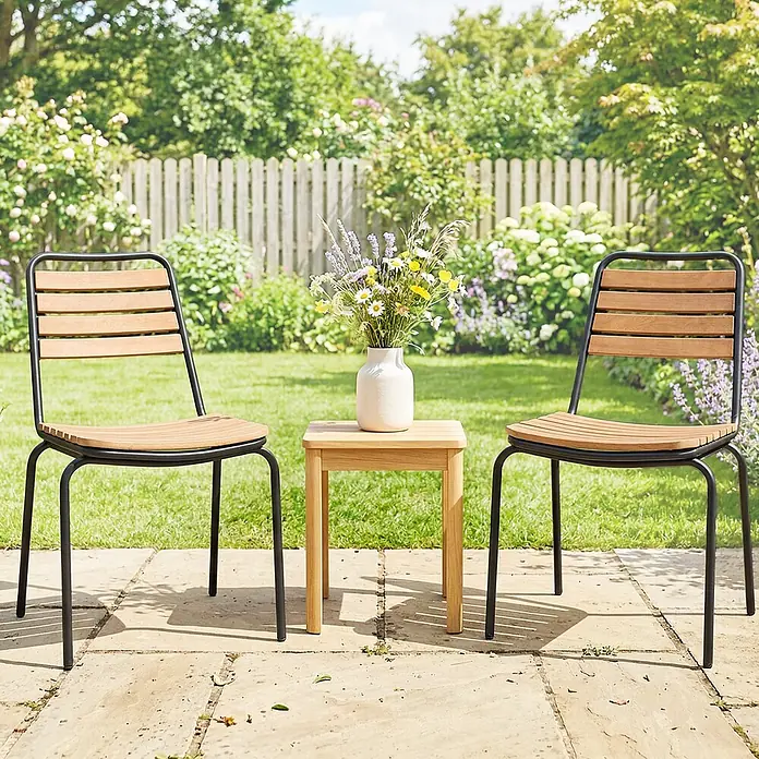Outsunny Gartenstuhl-Set - 2 Stk., Stahl, Eukalyptusholz, Stapelbar, Schwarz, Braun - Zwei Gartenstühle mit schwarzen Metallrahmen und Holzlatten, dazu ein passender Holznebentisch, im Garten.