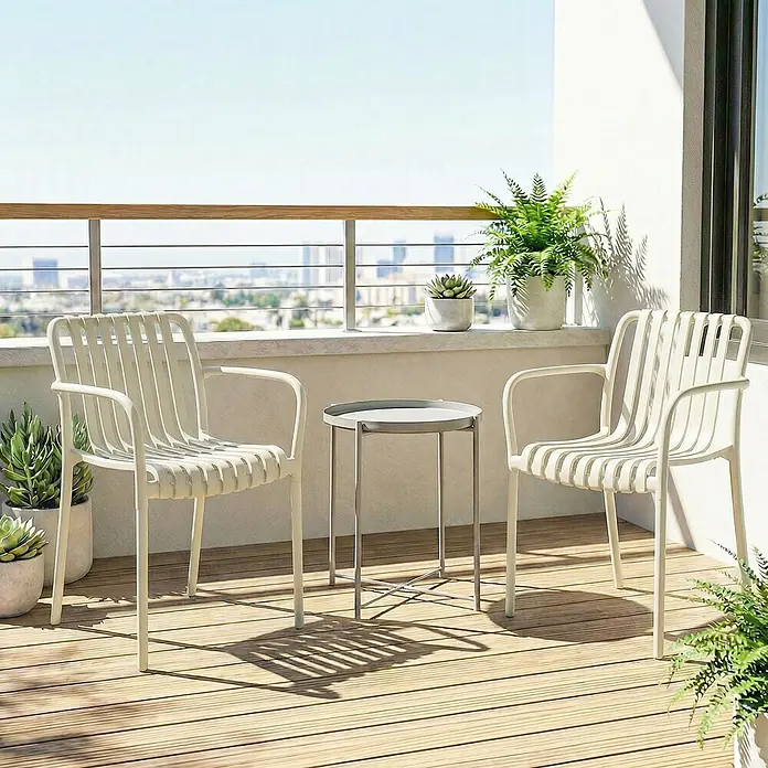 Outsunny Gartenstuhl-Set - 4 Stk., Kunststoff, Stapelbar, Cremeweiß - Zwei helle Lattenstühle und ein grauer Metalltisch auf einem sonnigen Balkon mit Pflanzen und Stadtblick.