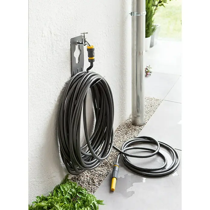 Neptun Wand-Schlauchhalterung - Metall, Geeignet für: Handelsübliche Wasserhähne - Gartenschlauch auf einer Halterung an der Wand, bereit für die Gartenarbeit. Der Schlauch ist aufgerollt und mit einem gelben Anschlussstück versehen.