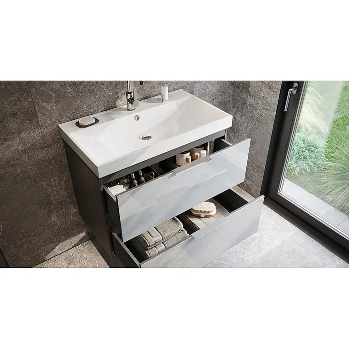 Germania Waschtischunterschrank GW-CELANO - B x T x H: 81 x 46 x 65 cm, Graphit/Silbergrau - Moderner Badwaschtisch mit weißem Einbauwaschbecken, dunkelgrauem Schrank und zwei offenen hellgrauen Hochglanzschubladen, gefüllt mit Toilettenartikeln und Handtüchern.
