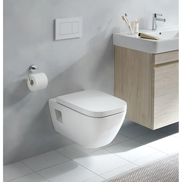 Geberit Renova Plan Wand-WC-Set - Spülrandlos, Ohne Spezialglasur, Spülform: Tief, WC Abgang: Waagerecht, Teilgeschlossene Form - Modernes weißes wandhängendes WC, Doppelspültaste und verchromter Toilettenpapierhalter neben einem hellen Holzwaschtisch im Bad.