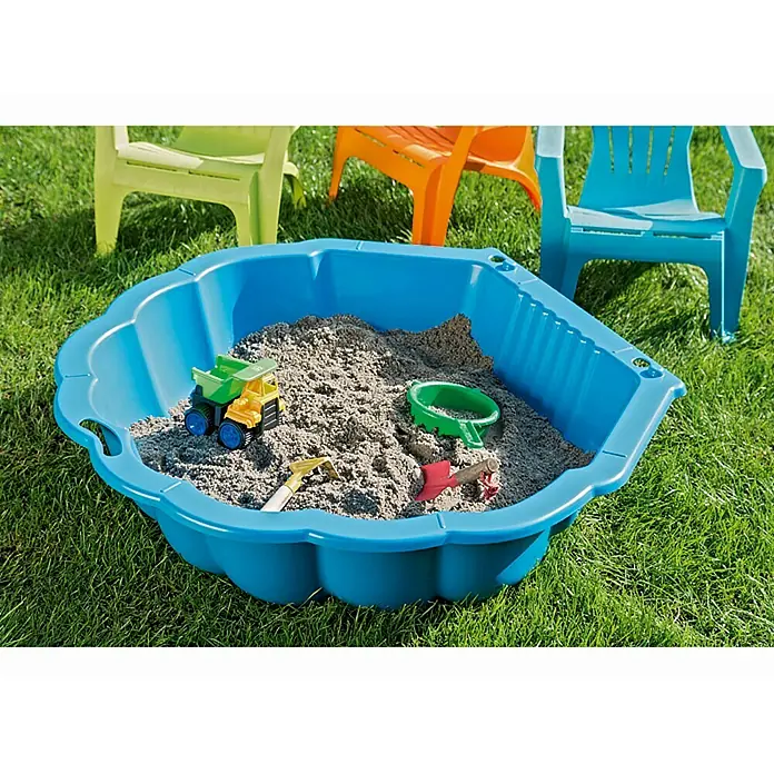 Wasser- & Sandmuschel Sandy - 88 x 102 x 21 cm, Blau - Ein blauer Sandkasten gefüllt mit Sand und Spielzeug, umgeben von grünen Rasen und bunten Kinderstühlen.