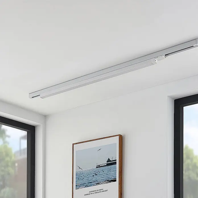 Arcchio LED-Spannseilsystem Harlow - weiß / opal, Neutralweiß - Silberne Decken-Vorhangschiene mit sichtbarem Motor über einem Fenster.