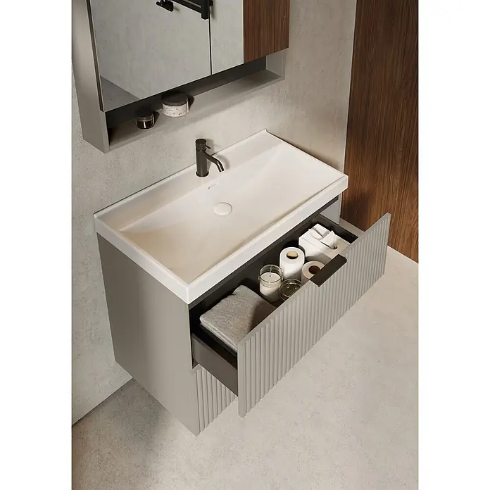 Riva Yasumi Waschtischunterschrank - B x T x H: 80 x 45,2 x 63,5 cm, Fume, Matt - Moderne hellgraue Badezimmervanität mit integriertem Waschbecken, dunkler Armatur und geöffneter Rillenschublade für Handtücher und Utensilien. Spiegelschrank darüber.