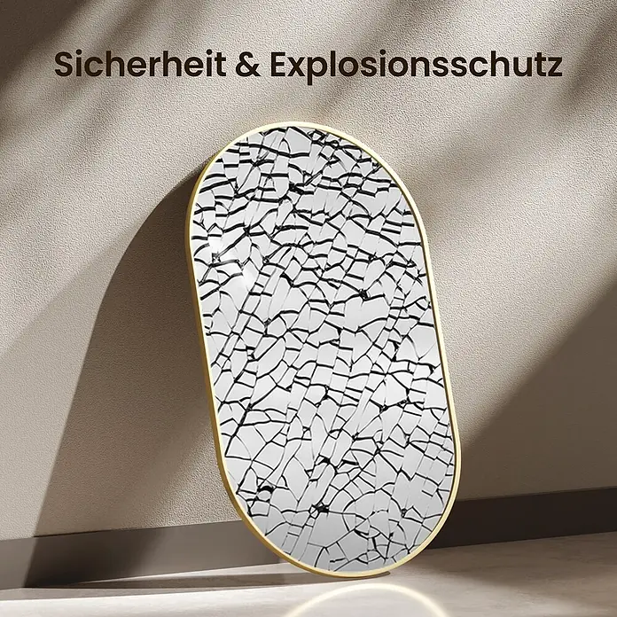 Emke Rahmenspiegel OM18 - 100 x 60 cm, Glas - Ovaler Spiegel mit goldenem Rahmen & Rissmuster, der Sicherheit & Explosionsschutz demonstriert, an eine Wand gelehnt.