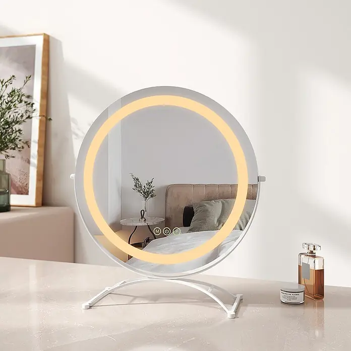 Emke Kosmetikspiegel CM07 - Rund, Weiß - Runder LED-Schminkspiegel mit weißem Standfuß, warmem Licht, spiegelt ein Schlafzimmer wider.