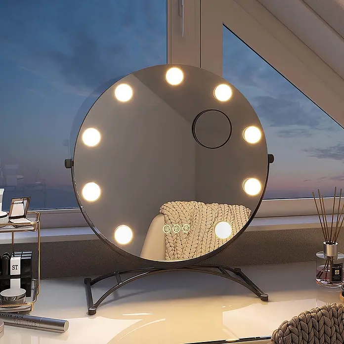Emke Kosmetikspiegel CM11 - Rund, Schwarz - Runder beleuchteter Schminkspiegel mit Touch-Bedienelementen und dunklem Metallständer auf einem Schminktisch.