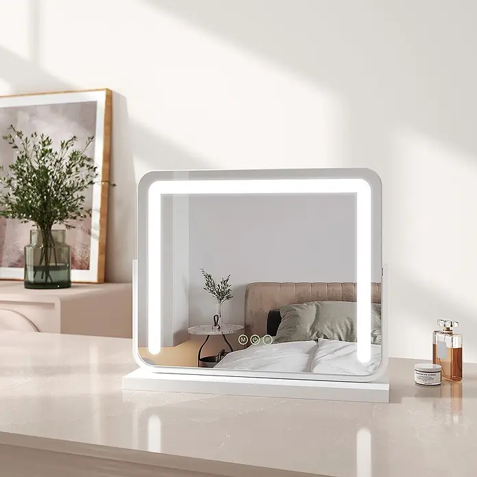 Emke Kosmetikspiegel CM08 - Rechteckig, Weiß - Weißer rechteckiger LED-Schminkspiegel mit integrierter Beleuchtung und Touch-Bedienelementen, der ein Schlafzimmer reflektiert.