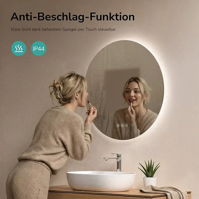 Emke Lichtspiegel Glowrim OLM03 -  - Runder LED-Spiegel mit Antibeschlagfunktion in einem Badezimmer, von einer Frau beim Auftragen von Lippenstift verwendet.