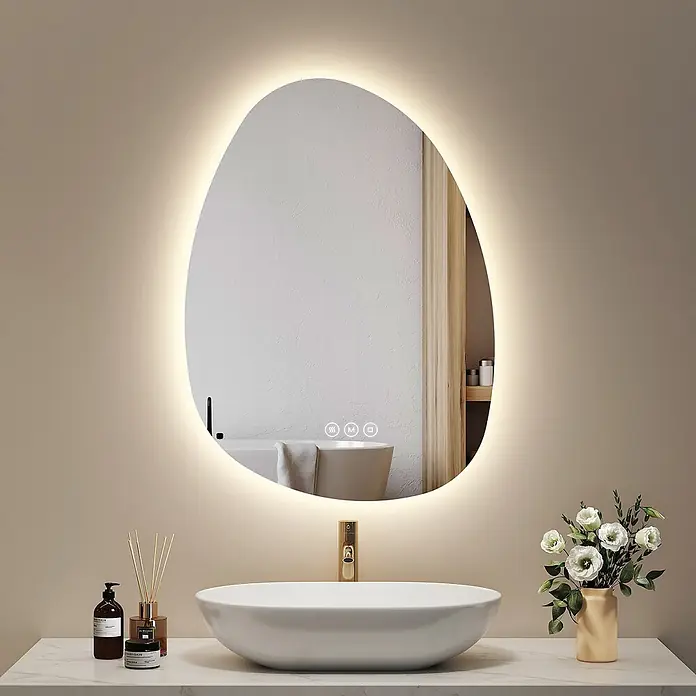Emke Lichtspiegel Glowrim LM34 - 75 x 55 cm - Moderner, unregelmäßig geformter LED-beleuchteter Badezimmerspiegel mit Anti-Beschlag- und Lichtsteuerung, über einem Waschbecken installiert.