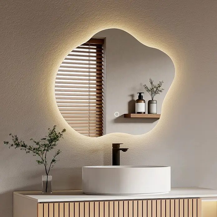 Emke Lichtspiegel Dimlite LM31 -  - Unregelmäßig geformter, LED-hinterleuchteter Spiegel in modernem Bad über einem Waschbecken. Er reflektiert ein Fenster mit Holzjalousien.