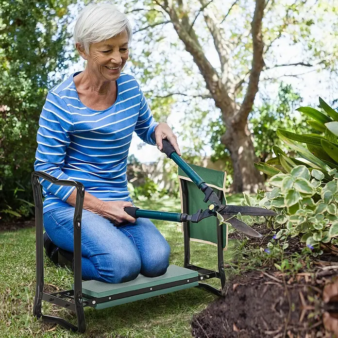 Outsunny Gartenbank Kniebank - Stahl, Metall, EVA Schaumstoff, Grün, Schwarz, Klappbar - Ältere Frau kniet auf einer schwarz-grünen Gartenbank/-knieschutz, beschneidet Pflanzen mit Heckenscheren im Garten.