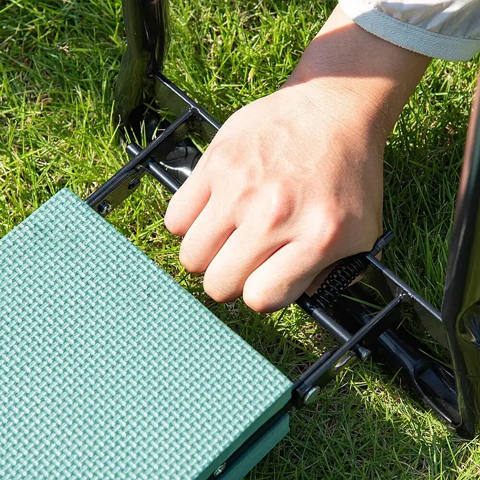 Outsunny Kniebank Schwarz+Dunkelgrün 58L x 28B x 49H cm -  - Person verstellt einen grünen Gartenhocker mit schwarzem Metallrahmen auf Gras.