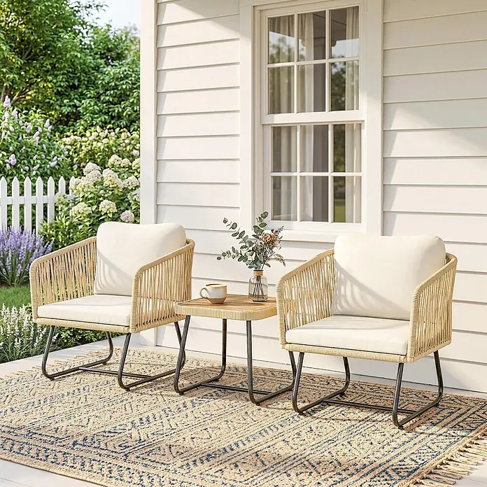 Outsunny Loungemöbel-Set - 3 -tlg., PP-Rattan, Stahl, Polyester, Akazienholz, Schaumstoff, PP-Baumwolle, inkl. Kissen, Beige, Cremeweiß, Teak - Outdoor-Sitzgruppe mit zwei beigefarbenen geflochtenen Stühlen, weißen Kissen und einem kleinen Beistelltisch auf einem gemusterten Teppich auf einer Veranda.