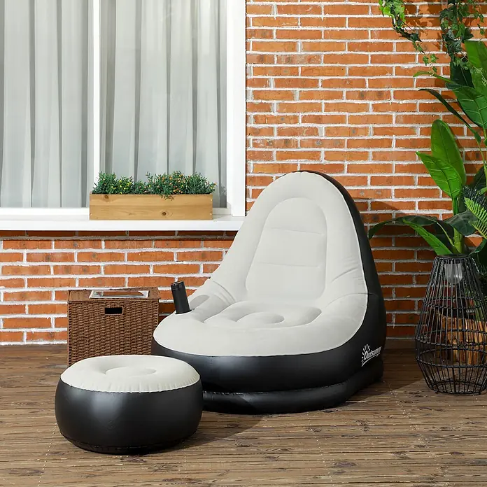 Outsunny Loungemöbel-Set Aufblasbarer Sessel - 2 -tlg., Kunststoff, Hellgrau, Schwarz - Aufblasbarer schwarz-weißer Sessel mit Hocker auf einer Holzterrasse vor einer Ziegelwand.