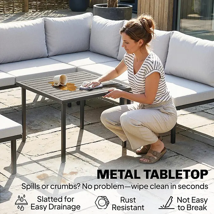 Outsunny Loungemöbel-Set - 6 -tlg., Metall, Polyester, Schaumstoff, PP-Baumwolle, Verstellbare Füße, Hellgrau - Eine Frau reinigt einen dunkelgrauen Lamellen-Metall-Gartentisch nach einem Verschütten, was die pflegeleichte Oberfläche zeigt.