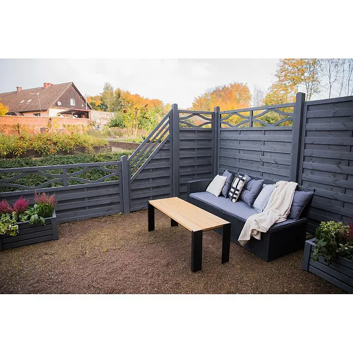 Werth Holz Sichtschutzelement Verona - B x H: 89 x 179 cm, Holz, Grau - Außenbereich mit dunkelgrauem Holzzaun, schwarzem Rattan-Sofa mit grauen Kissen und hellem Holztisch auf Kiesboden.