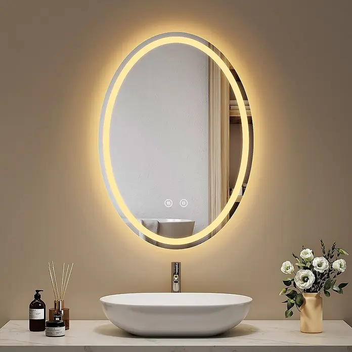 Emke Lichtspiegel Glowrim OLM19 -  - Ein ovaler Badezimmerspiegel mit warmer LED-Hintergrundbeleuchtung und Touch-Bedienelementen über einem Aufsatzwaschbecken.