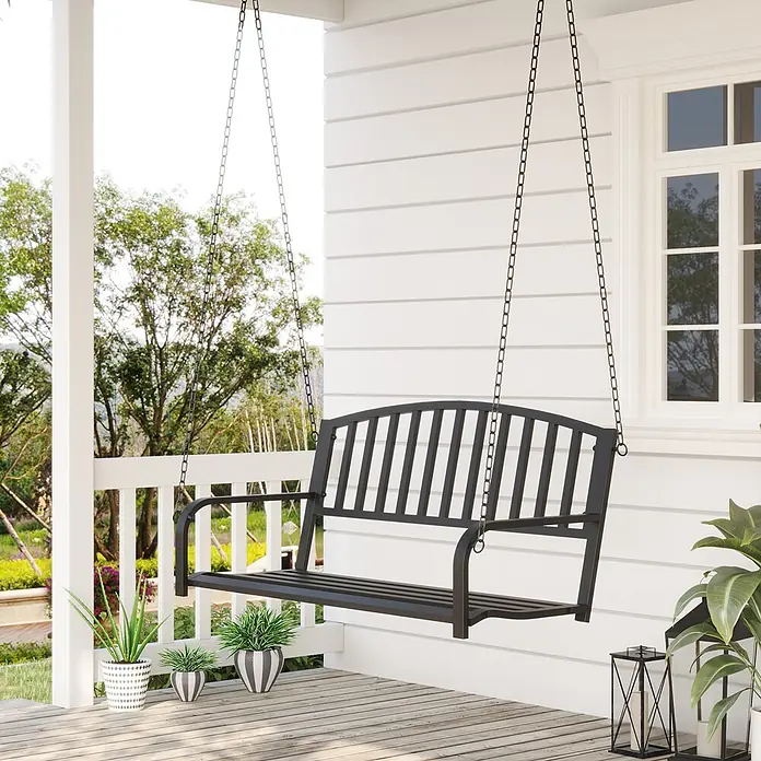 Outsunny Hängebank - B x T x H: 60 x 60 x 53 cm, Metall, Schwarz - Schwarze Metall-Verandaschaukel, an Ketten auf einer weißen Veranda hängend, mit Grün im Hintergrund.