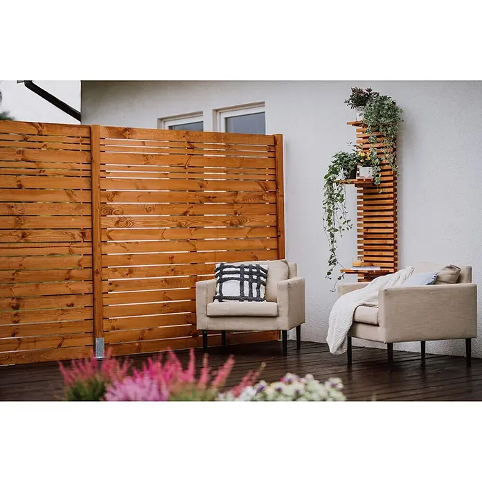 Werth Holz Sichtschutzelement Göteborg - B x H: 179 x 149 cm, Holz, Braun - Terrasse mit zwei beigefarbenen Sesseln, einem Sichtschutzzaun aus Holzlamellen und einem Regal mit Pflanzen auf dunklem Holzdeck.