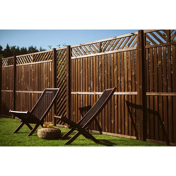 Werth Holz Rankgitter Victoria - 44 x 179 cm, Holz, Braun - Dunkelbrauner Holzzaun mit dekorativem Gitteraufsatz, der einen sonnigen Rasen mit zwei Liegestühlen umschließt.