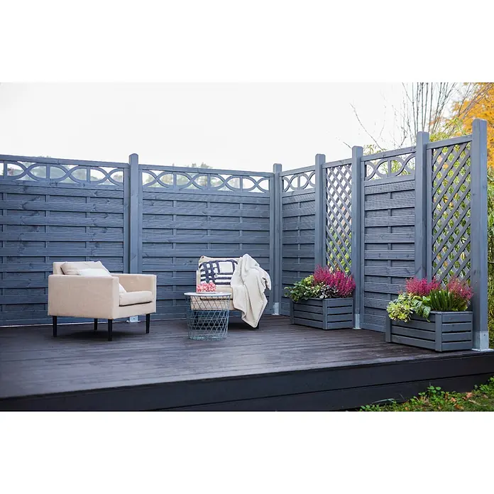 Werth Holz Rankgitter Milano - 59 x 179 cm, Holz, Grau - Dunkelgrauer Gartenzaun und passendes Terrassendeck bilden einen Outdoor-Loungebereich mit Möbeln und Pflanzkübeln.