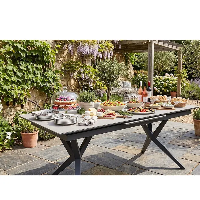 Bene Living Gartentisch Valor - L x B x H: 210 x 90 x 75 cm, Aluminium Gestell mit gesinnerter Tischplatte aus Keramik, Rechteckig, Anthrazit - Moderner, ausziehbarer Gartentisch mit dunklen Kreuzbeinen und heller Platte, für eine Gartenfeier gedeckt.