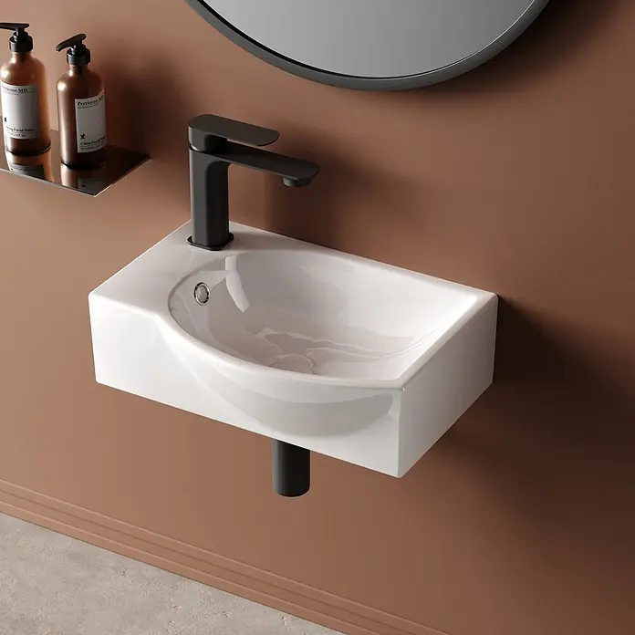 Emke Waschbecken CB14 - B x L: 28 x 40,5 cm, Hahnloch: Links, Mit Überlauf, Weiß - Wandhängendes weißes Keramikwaschbecken mit mattschwarzem Wasserhahn in modernem Bad. Zwei braune Produktflaschen stehen auf einem Chromregal.