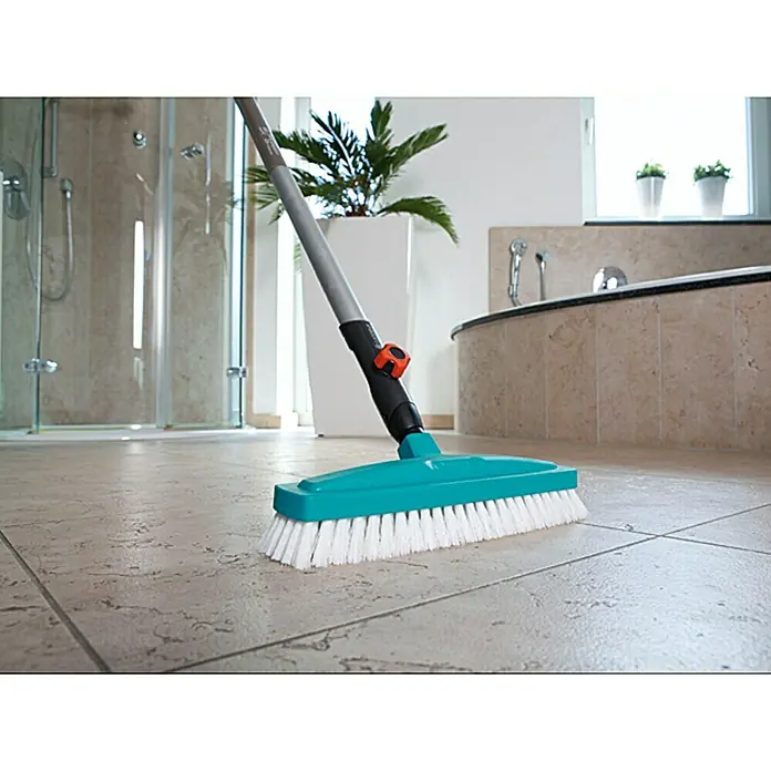 Gardena Combisystem Schrubber - Arbeitsbreite: 30 cm, Material Gerätekopf: Kunststoff - Bild einer blauen GARDENA Reinigungsbürste mit weißen Borsten, die auf einem gefliesten Boden steht.
