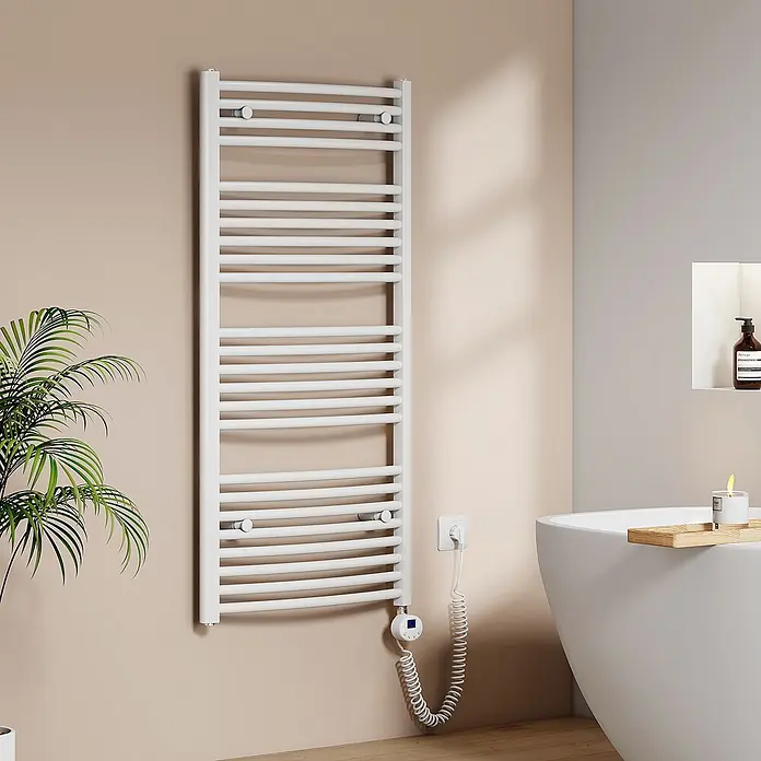 Emke Elektro-Badheizkörper ArcWarm PCTR -  - Weißer elektrischer Handtuchheizkörper mit digitalem Thermostat und Spiralkabel, an einer Badezimmerwand neben Pflanze und Badewanne montiert.