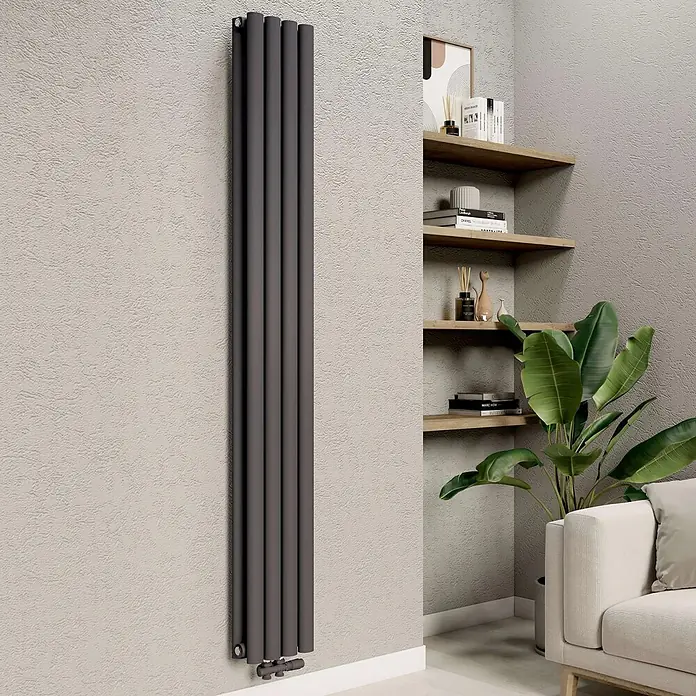 Emke Designheizkörper OR - B x H: 24 x 180 cm, Anthrazit - Hoher anthrazitfarbener vertikaler Säulenheizkörper an einer Wand in einem modernen Wohnraum, neben Regalen und einer Pflanze.