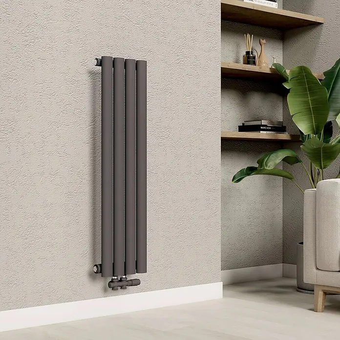 Emke Designheizkörper OR - Anthrazit - Dunkelgrauer vertikaler Heizkörper, an einer strukturierten Wand in einem modernen Wohnraum installiert.