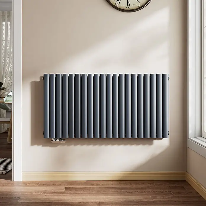 Emke Designheizkörper OR - Anthrazit - Dunkelgrauer Flachheizkörper an einer Wand, beheizt einen Raum.