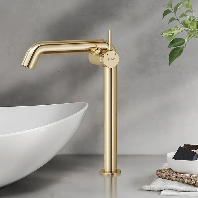 Emke Waschtischarmatur Flowcurv XF24 - Gold, Glänzend - Ein goldener, hoher Waschtischmischerhahn mit zylindrischem Design, neben einem weißen Aufsatzwaschbecken.