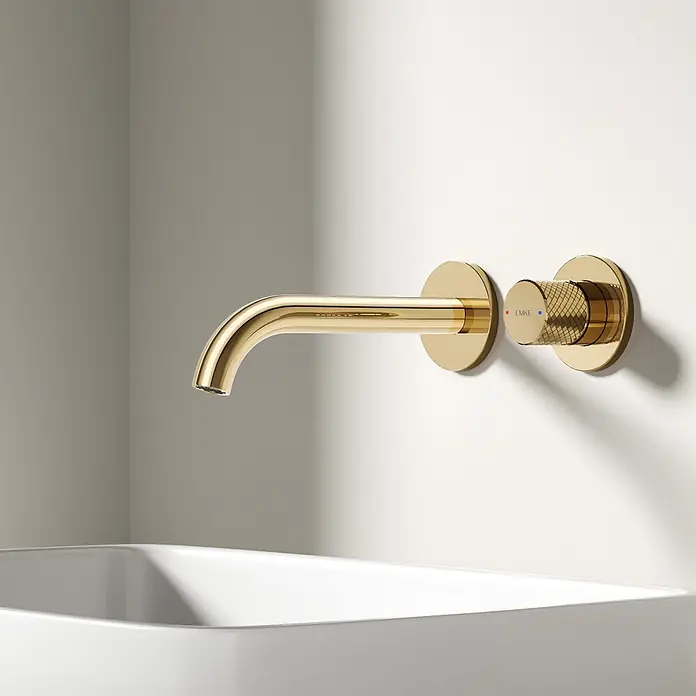 Emke Waschtischarmatur Griprill XF22 - Gold, Glänzend - Goldene wandmontierte Armatur mit texturiertem Griff über einem weißen Waschbecken.