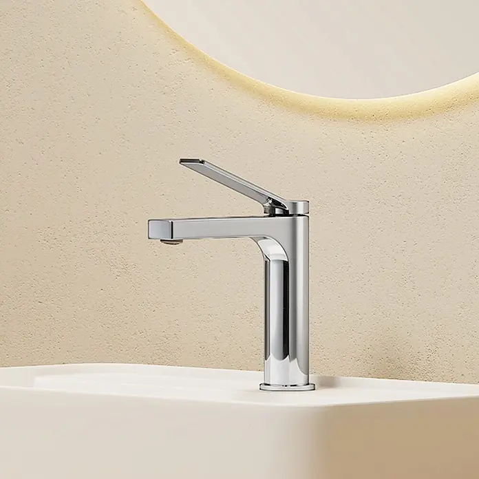 Emke Waschtischarmatur Arcspout XF21 - Chrom, Glänzend - Glänzender Chrom-Waschtischmischer mit offenem Hebel auf einem hellen Waschbecken vor einer strukturierten beigen Wand.